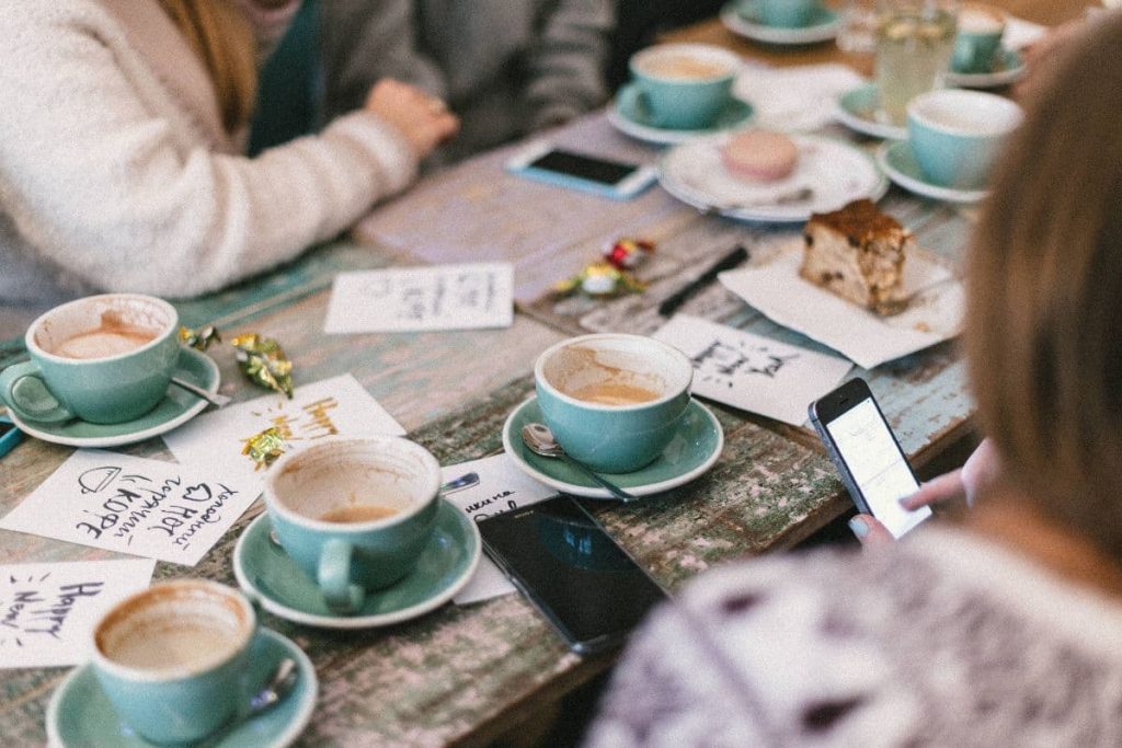 Groupe de personnes assises à une table pour réseauter autour d'un café.